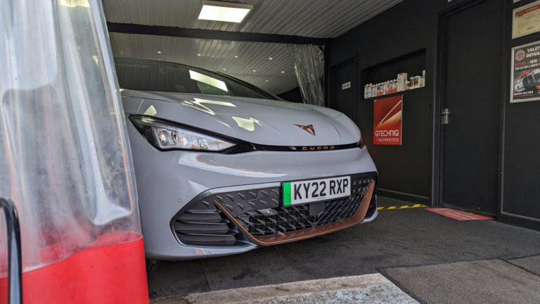 The front of the CUPRA born edging out of a garage